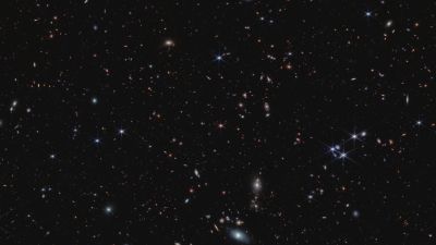 JWST NIRCam image of quasar J0100+2802, an ultra-luminous active supermassive black hole in the early universe, surrounded by thousands of faint galaxies.