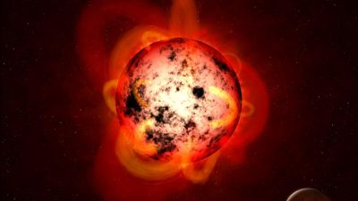 Illustration of an M-dwarf star with starspots on its surface, similar to the polar starspot observed by JWST on TOI-3884.