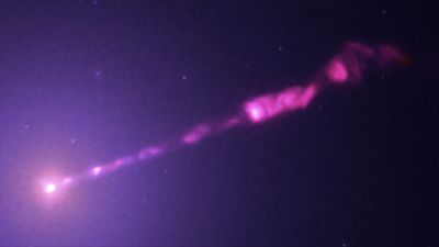 Composite image of the M87 supermassive black hole's X-ray jet, combining data from Chandra (X-ray), Hubble (optical), Webb (infrared), and the VLA (radio).