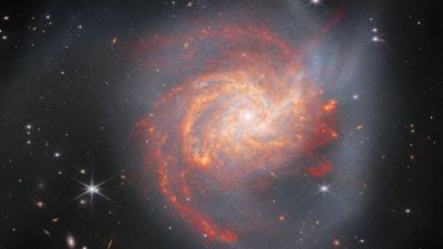 JWST NIRCam and MIRI infrared image of the peculiar luminous infrared galaxy NGC 3256, a head-on spiral-spiral merger about 120 million light-years away in the constellation Vela.