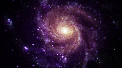 Composite image of spiral galaxy M101 showing purple Chandra X-ray data over a Hubble optical image, where hypersoft X-ray sources were identified.