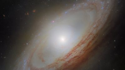 Hubble image of the spiral galaxy NGC 4698 in the Virgo Cluster, its ring-like dusty spiral arms surrounding a bright bulge that extends above and below the disc.
