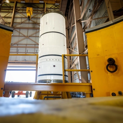 The left-hand forward solid rocket booster segment for NASA’s Artemis III SLS (Space Launch System) rocket is removed from its...
