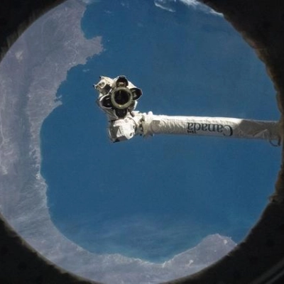 The Canadarm2 robotic arm is pictured from a window on the International Space Station