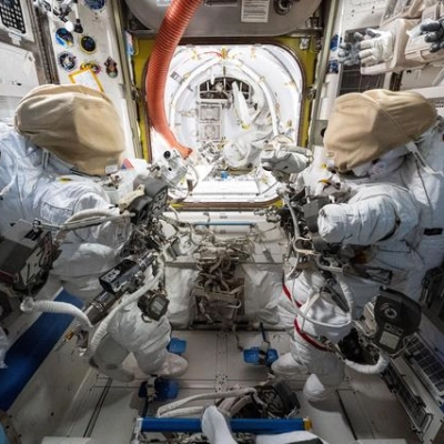 Two spacesuits are staged inside the International Space Station's Quest airlock
