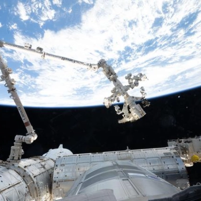 The Canadarm2 robotic arm extends from a data grapple fixture on the International Space Station