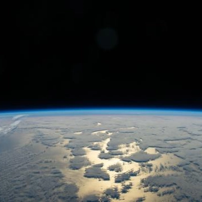 Earth's thin blue atmosphere traces the planet's horizon above the Pacific Ocean