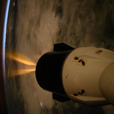 A SpaceX Dragon spacecraft fires its Draco engines