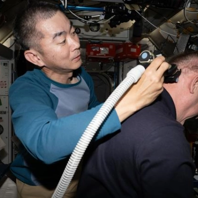 JAXA astronaut Kimiya Yui trims NASA astronaut Mike Fincke's hair aboard the International Space Station