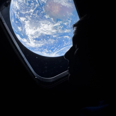 art002e009007 (April 4, 2026) - NASA astronaut and Artemis II Commander Reid Wiseman peers out of one of the Orion...