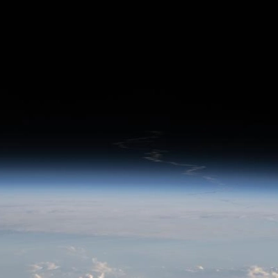 The exhaust plume left behind by Artemis II is pictured from the International Space Station